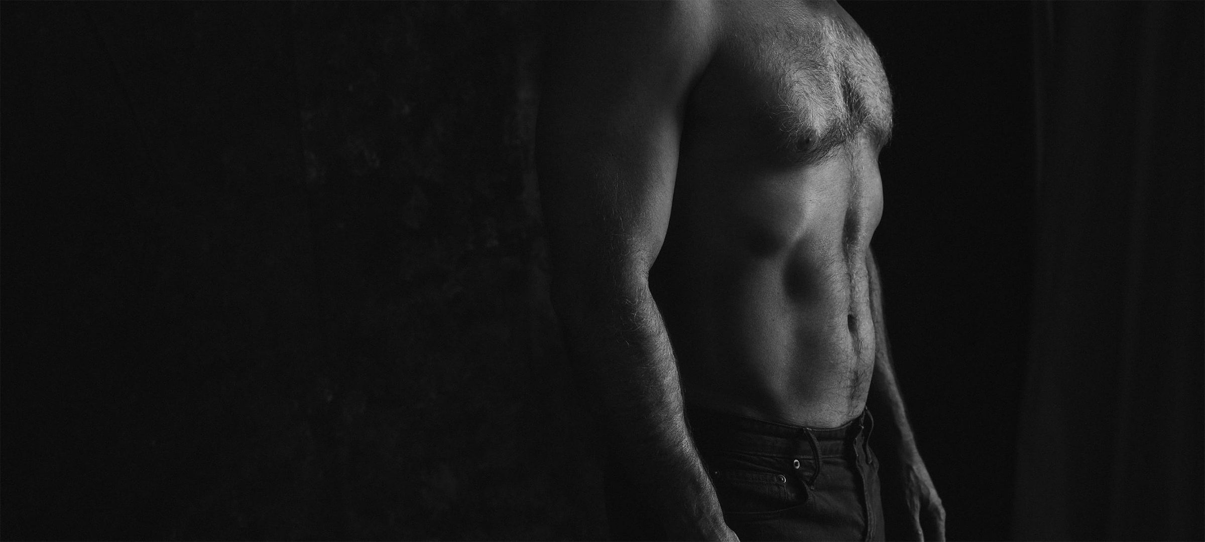 Black and white image of a man's chiseled abs