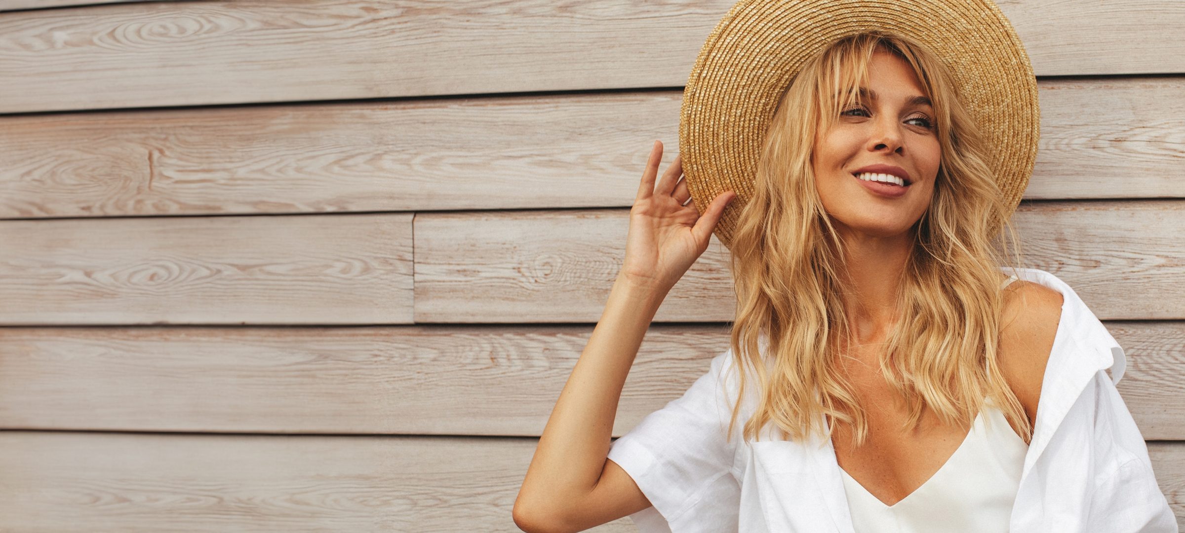 Woman with long blonde hair wearing a straw hat